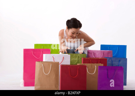 Young woman looking into shopping bags Stock Photo
