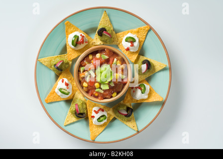 Nachos with dips and a bowl of salsa Stock Photo