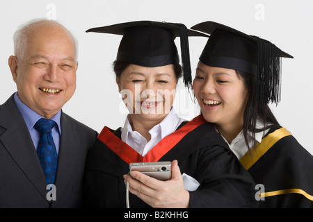 Professor with two female graduate students looking at a digital camera Stock Photo