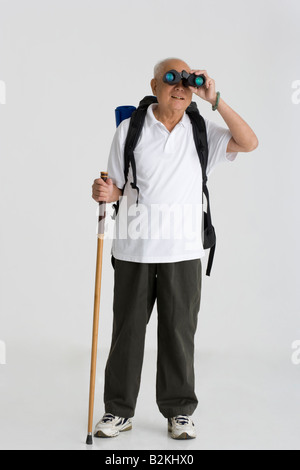 Senior man looking through a pair of binoculars Stock Photo