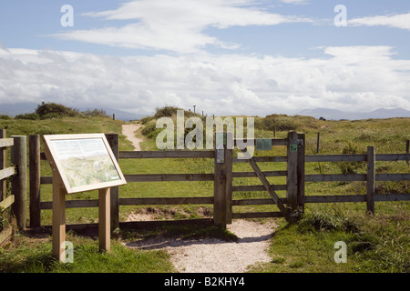 Newborough Warren National Nature Reserve information board and footpath by gate. Newborough Isle of Anglesey North Wales UK Stock Photo