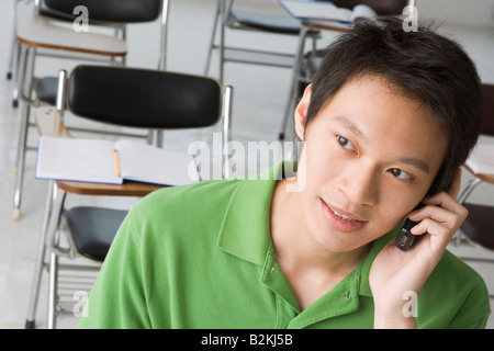 Close-up of a young man talking on a mobile phone in the classroom Stock Photo