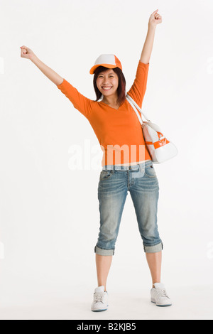 Woman standing with her arms raised and smiling Stock Photo - Alamy