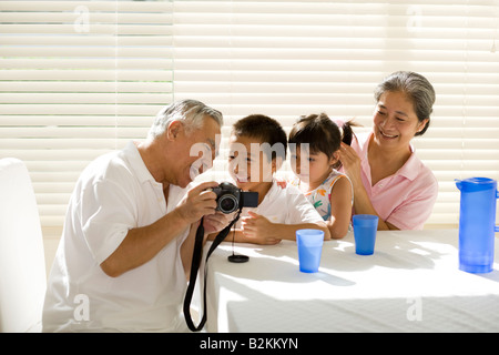 Senior couple sitting with their grandchildren and smiling Stock Photo
