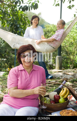 Portrait of a mature woman holding a champagne flute with her friends smiling in the background Stock Photo