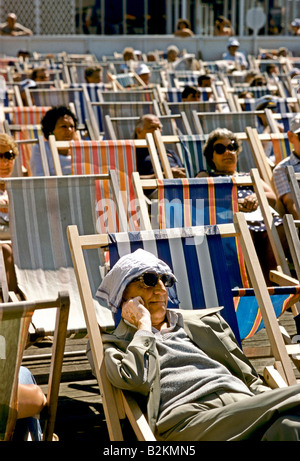man sitting in deckchair in blackpool with top of his head covered with handkerchief Stock Photo