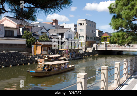 On a sunny day tourists ride a boat through the canals of the city of Matsue in Shimane Prefecture Stock Photo
