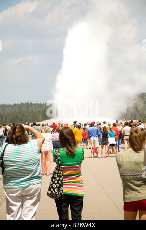 Tourists watching the eruption of the Old Faithful geyser at Yellow Stone National Park Stock Photo