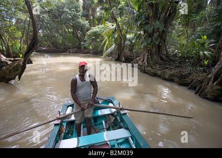 Albert Lawrence  of Albert's Shore Services guides his boat up the Indian River in Portsmouth, Dominica, West Indies Stock Photo
