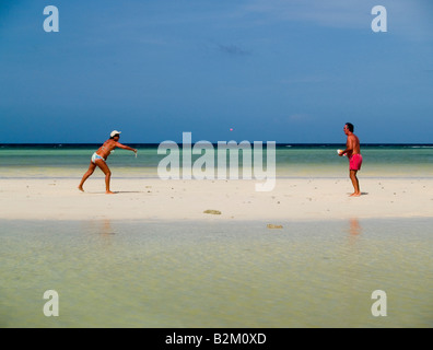 couple playing paddleball on the beach on Ko Tao Island in Thailand Stock Photo