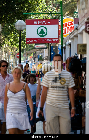 Pedestrians pass by a Spar store in Cala Ratjada, Majorca, Spain Stock Photo