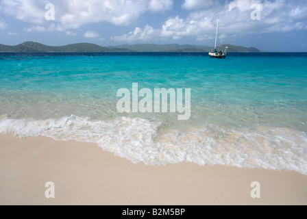 A cruising sailboat anchored next to Sandy Cay in the British Virgin Islands Tortola and St John is visible in the background Stock Photo