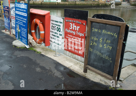 Advertising boards for fishing trips in Whitby, Yorkshire Stock Photo