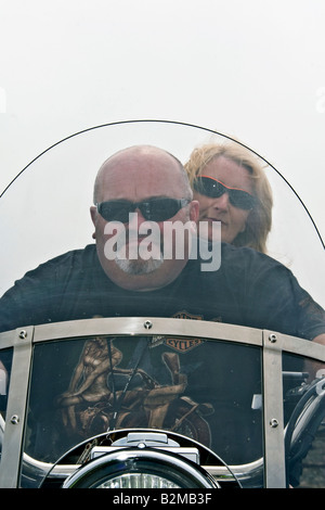 View of two bikers seated together looking through the windscreen of their Harley Davidson motorbike in Arbroath , UK Stock Photo