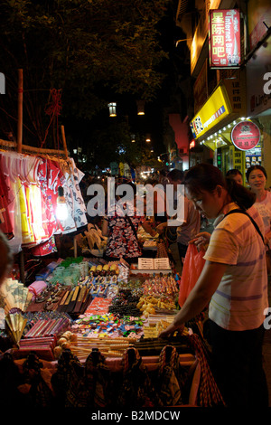 Chinese tourists browse stalls selling souvenirs at a night market in Yangshuo Guangxi China Stock Photo