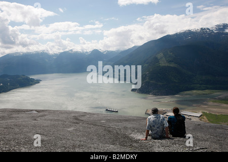 hikers enjoying the view from the top of the stawamus cheif overlooking Howe Sound Stock Photo