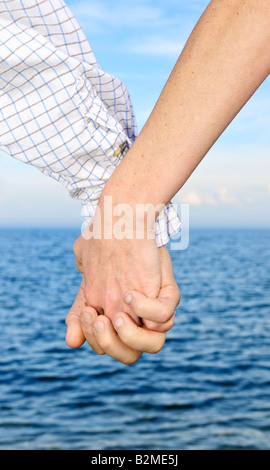 Mature romantic couple holding hands on the beach Stock Photo