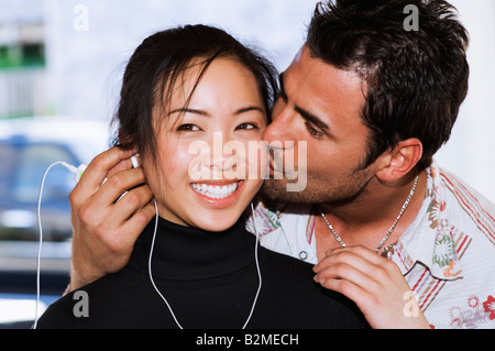 Young exotic girl and boy couple listening to music kissing Stock Photo