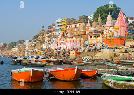 People perform their daily bathing and prayer rituals around Dasaswamedh Ghat with empty tourist boats in the foreground. Stock Photo