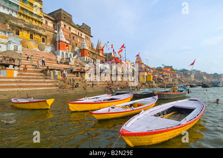 Wide angle view of people on Ahilyabai Ghat performing their daily ritual with empty tourist boats in the foreground. Stock Photo