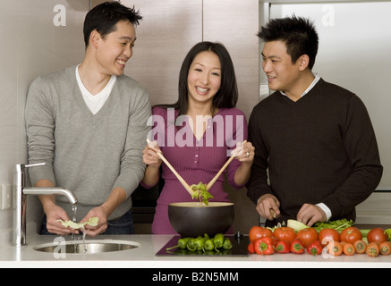 View of young men looking at a woman while working in a kitchen Stock Photo