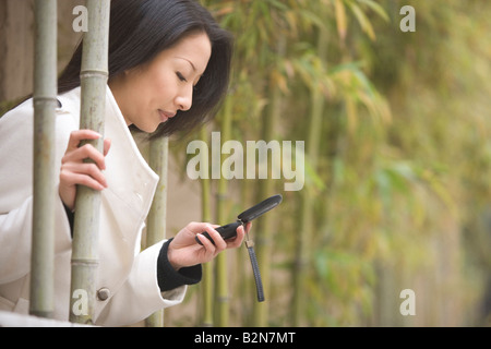 Side profile of a businesswoman operating a mobile phone, Shanghai, China Stock Photo