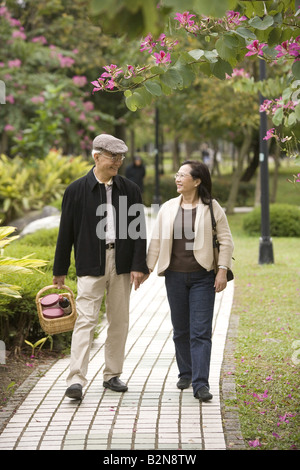 Senior couple walking in a park and looking at each other Stock Photo
