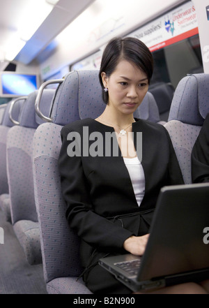 Businesswoman using a laptop in a train Stock Photo