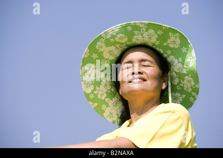 Low angle view of a senior woman wearing a sunhat and smiling Stock Photo