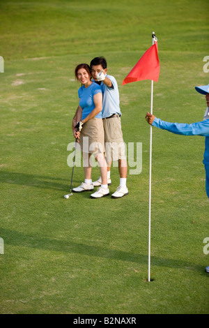 Side profile of a mature man teaching a mature woman how to play golf Stock Photo
