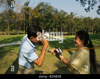 Side profile of a mature man taking a picture of a mature woman Stock Photo