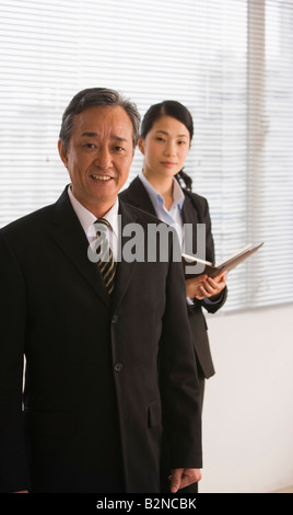 Businessman with a businesswoman standing in an office Stock Photo