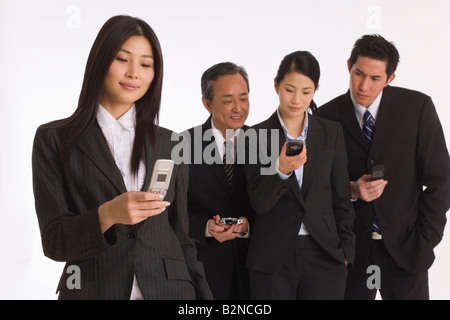 Four business executives using their mobile phones Stock Photo
