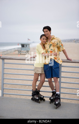 Young woman embracing a young man and smiling, Huntington Beach, California, USA Stock Photo