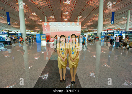 Two Young Airport Information Booth Employees at Beijing International Airport Stock Photo