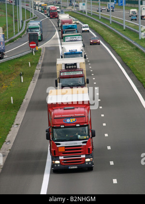Long line of trucks driving north towards Holland on the E19 near the border at Hazeldonk Belgium Stock Photo