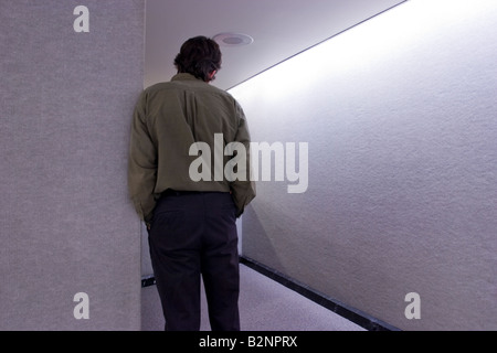 Man leaning against a wall in an office building Model Released Stock Photo