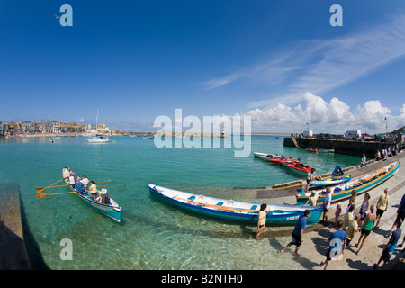 Youngsters rowing a cornish pilot gig in the old harbour harbor in summer sunshine St Ives Cornwall West Country England UK GB Stock Photo