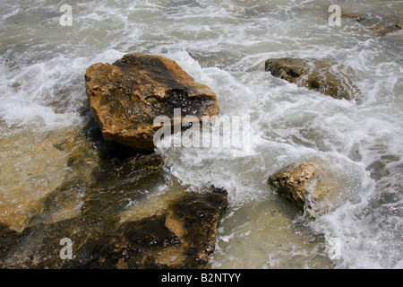 Ocean waves splash against beach with rocks background, Cliffs in the ...