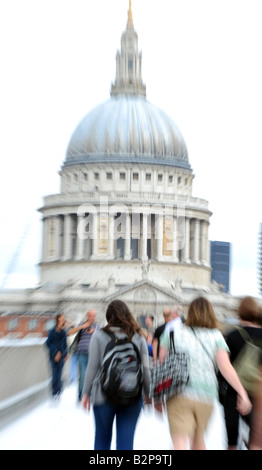 people walking over the Millennium Bridge London with st Paul's cathedral in the background Stock Photo