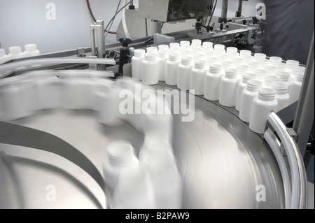 Pill Tablet Medicine Bottles Being Filled In Pharmaceutical Bottling Assembly Line Plant Stock Photo