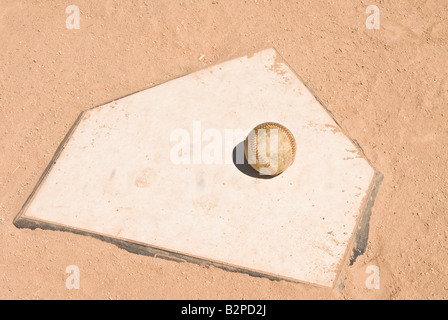 A baseball sits on home plate during a game Stock Photo