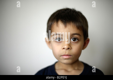 Six year old boy mixed race indian ethnic Hands of father holding his face Stock Photo