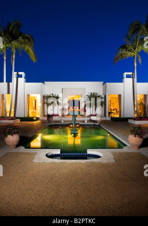 Evening exterior of a large white modern house with a swimming pool Stock Photo