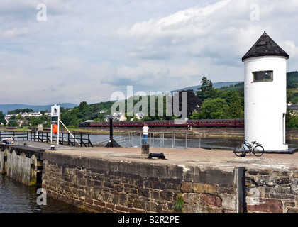 A Steam train is passing through Corpach on a sunny morning en route to Mallaig from Fort William in Scotland. Stock Photo