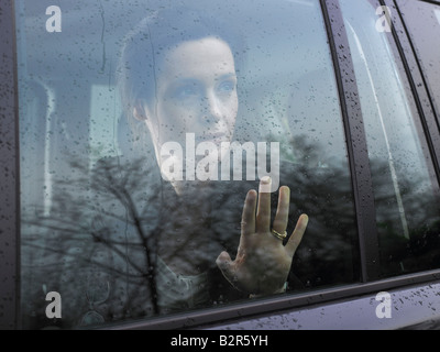 Woman looking through a car's window Stock Photo