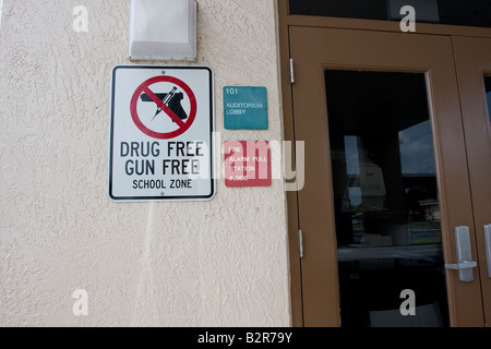 Gun and Drug Free School Zone Sign with Firearm and Needle in Red Circle and Slash over Handgun Stock Photo