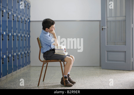 School boy sitting with books