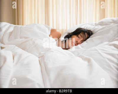 Woman sleeping in bed Stock Photo
