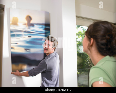 Couple hanging a painting Stock Photo